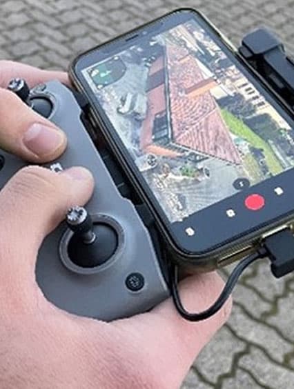 Operatore tecnico che esegue un sopralluogo del tetto tramite drone professionale per analisi dettagliata della copertura.